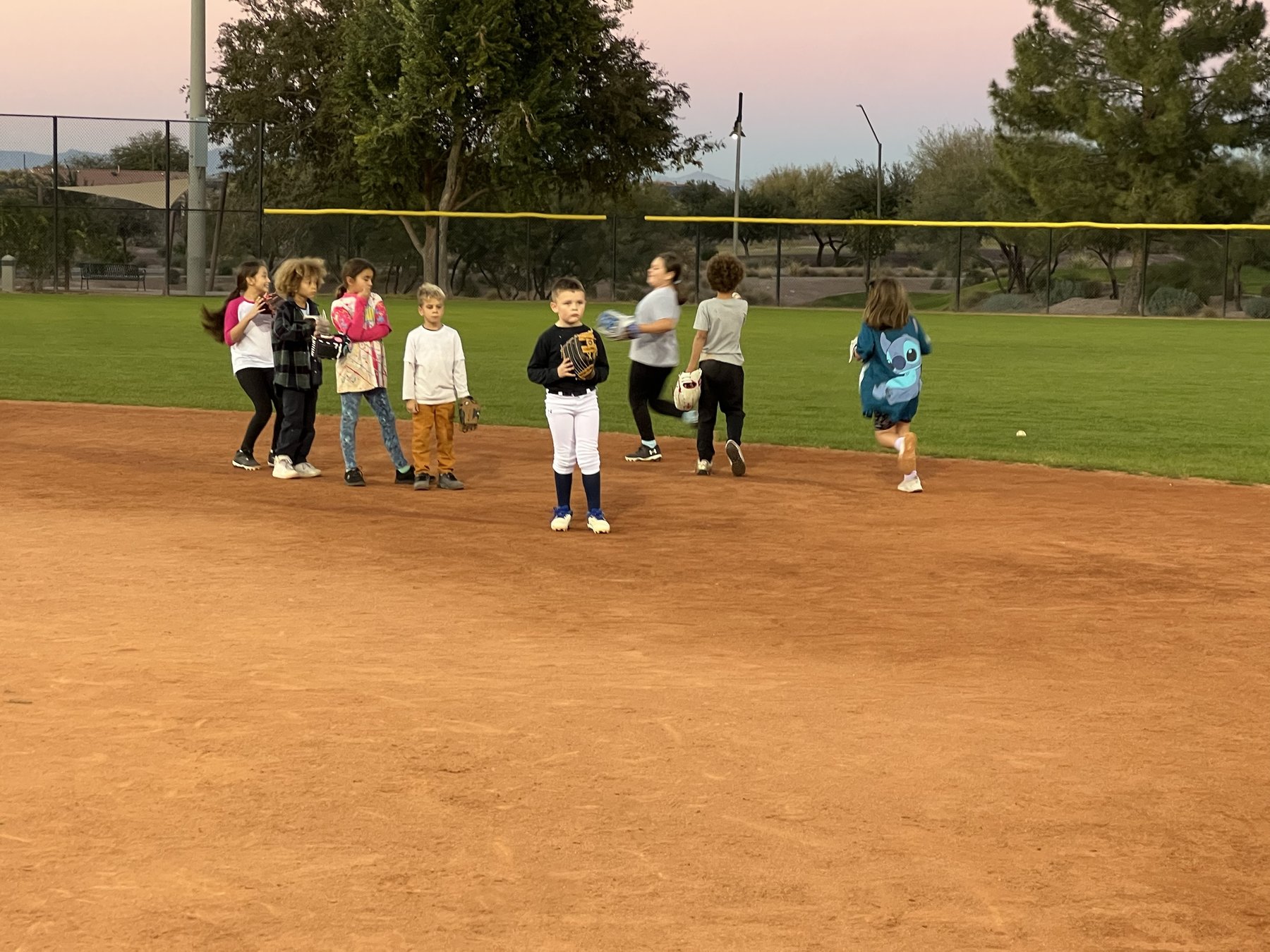 Young players with their gloves on the infield