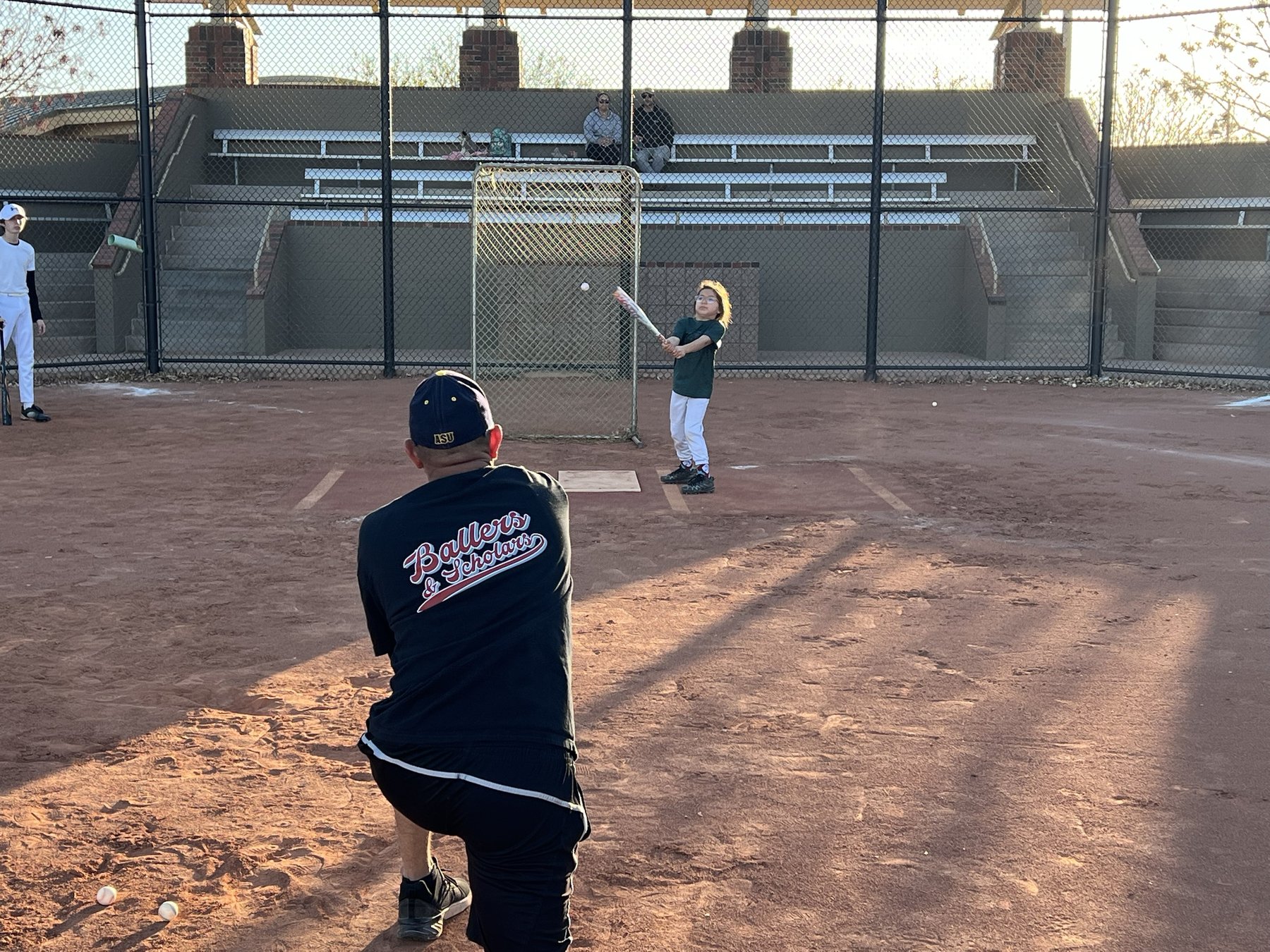 Coach Rudy pitching to a young hitter at a Ballers & Scholars clinic